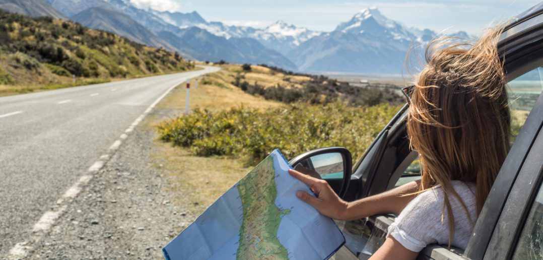 Portrait of young woman in car looking at map © swissmediavision/GettyImages